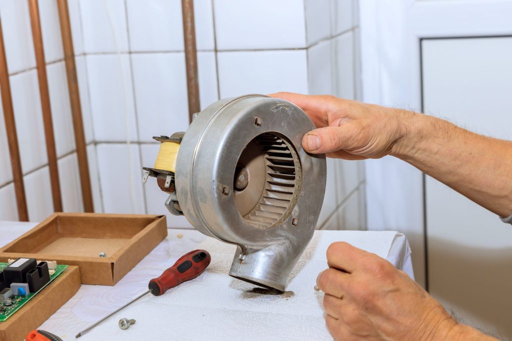 A blower housing and its squirrel-cage wheel held on a workbench