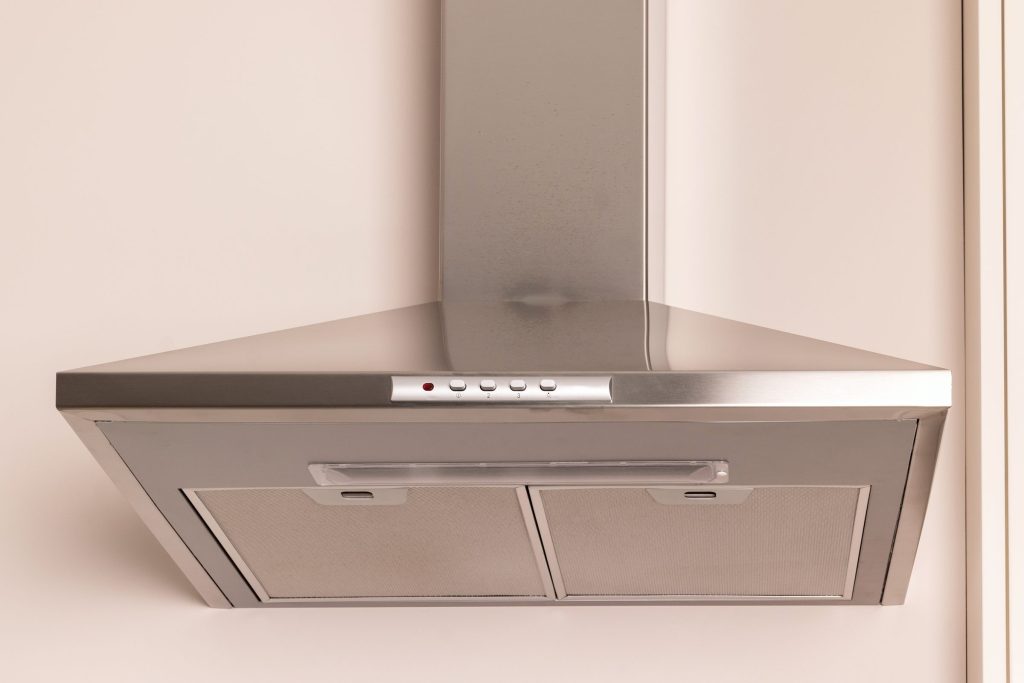 A stainless chimney hood against a plain wall
