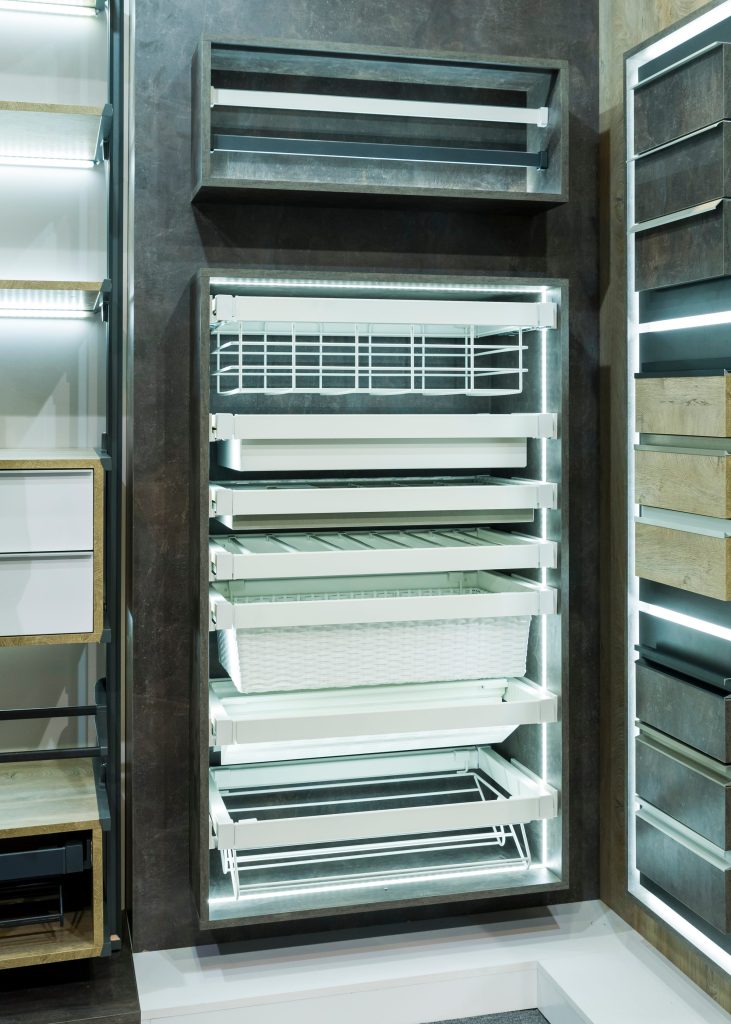 A lit refrigeration column with wire baskets and glass shelves inside