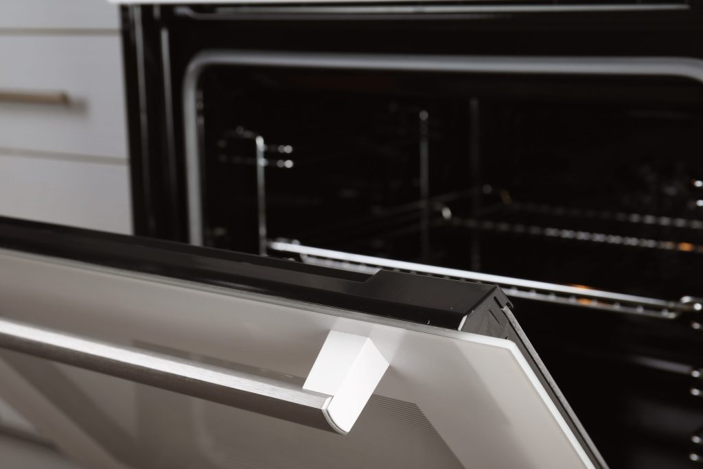 The door of a built-in oven standing ajar