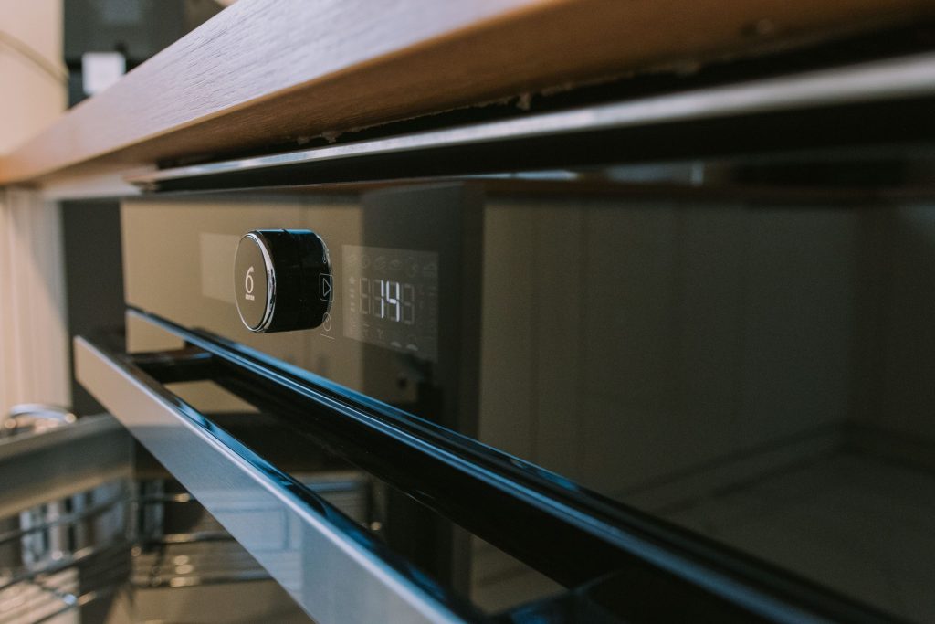 The fascia of a built-in oven, dial and display lit