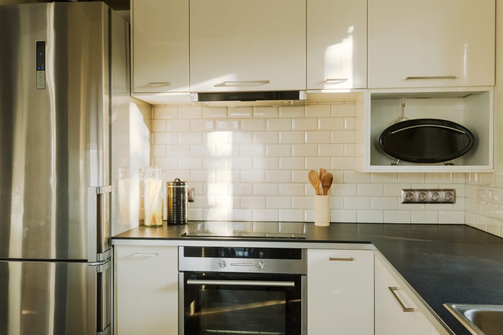 A galley kitchen with a built-in oven in a run of steel appliances