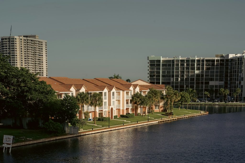 Low-rise condominiums along the water with taller towers behind them
