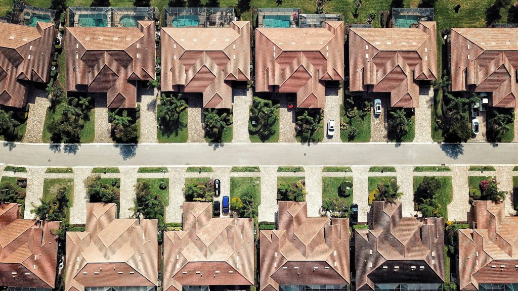 A row of tile-roofed houses with pools and driveways, straight down from the air