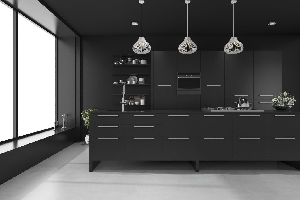 A black galley kitchen with three pendant lights and a tall window at the end
