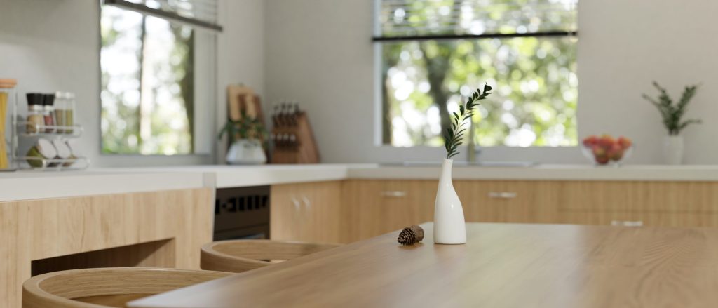 An oak kitchen run under a long window with a table in the foreground