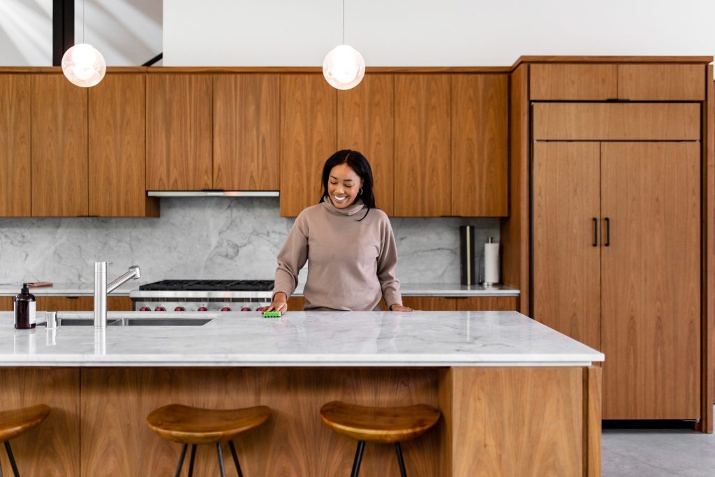 A walnut kitchen with a marble island, a pro range and a tall panelled column