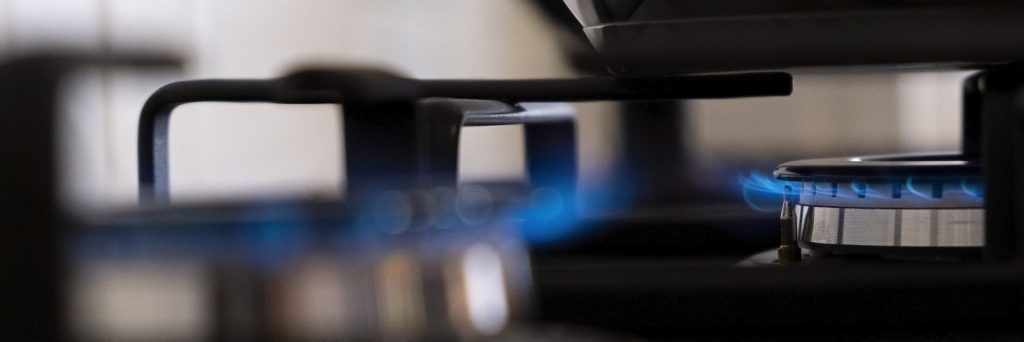 Two burners alight side by side across a professional rangetop