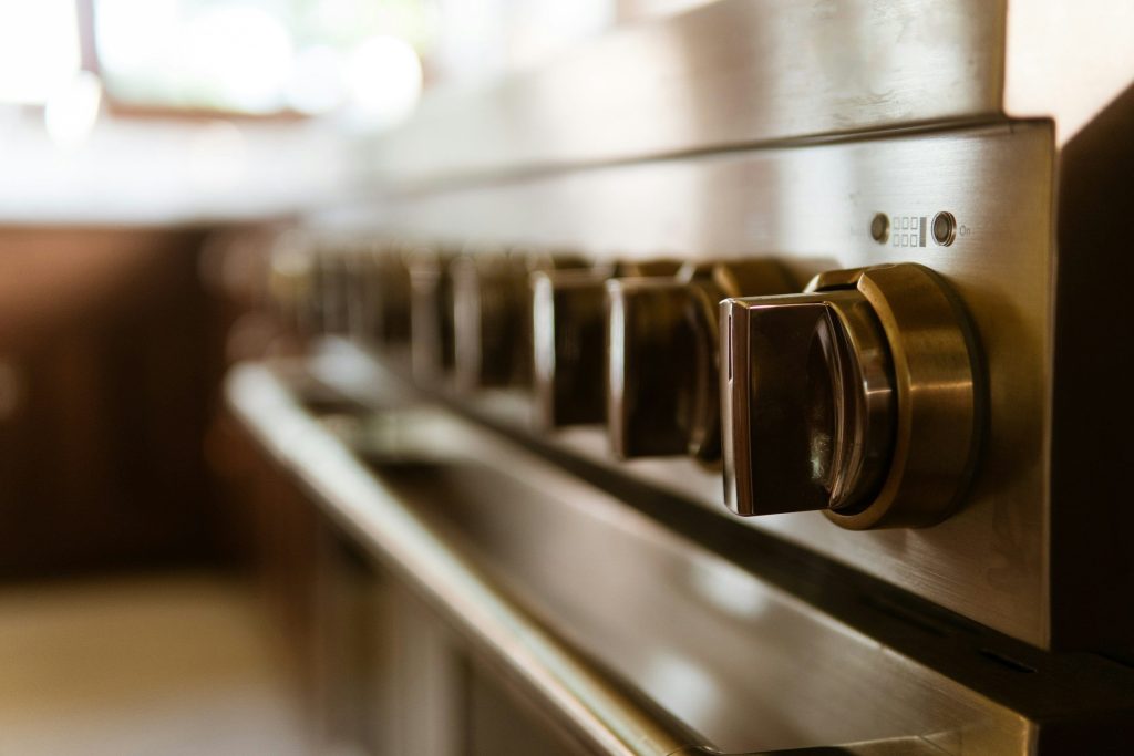 A row of brass control knobs along the front of a range